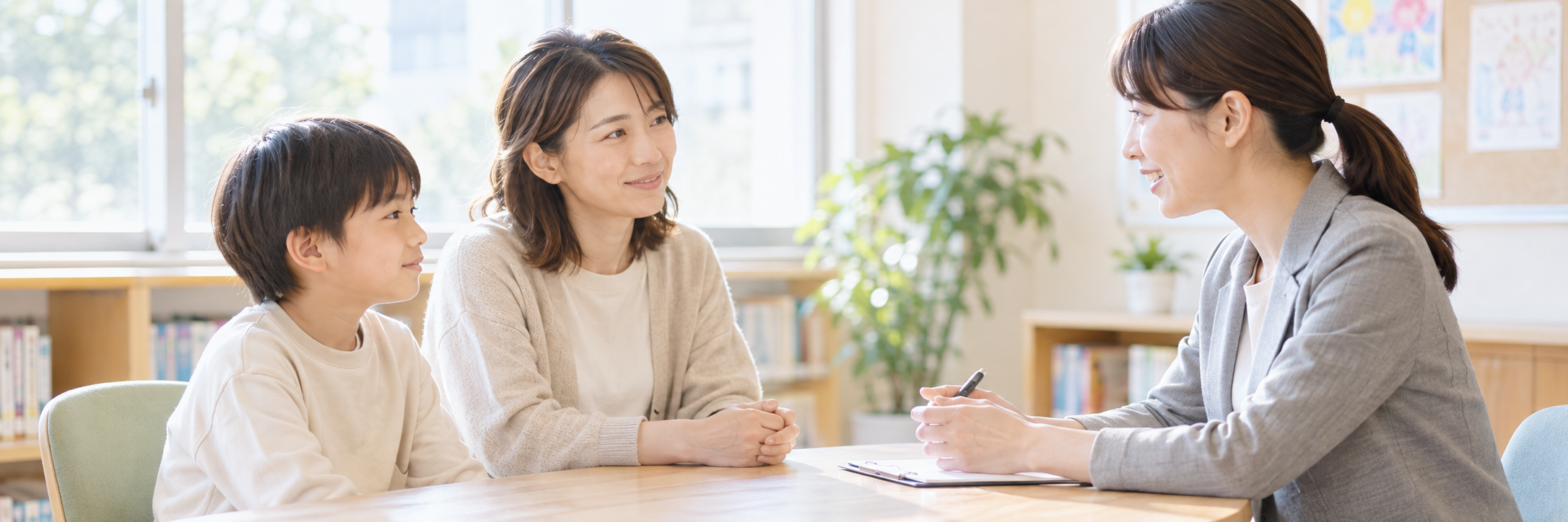 子どもと保護者が相談員と落ち着いて話しているイメージ